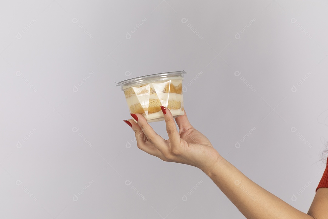 Mão segurando pote de bolo