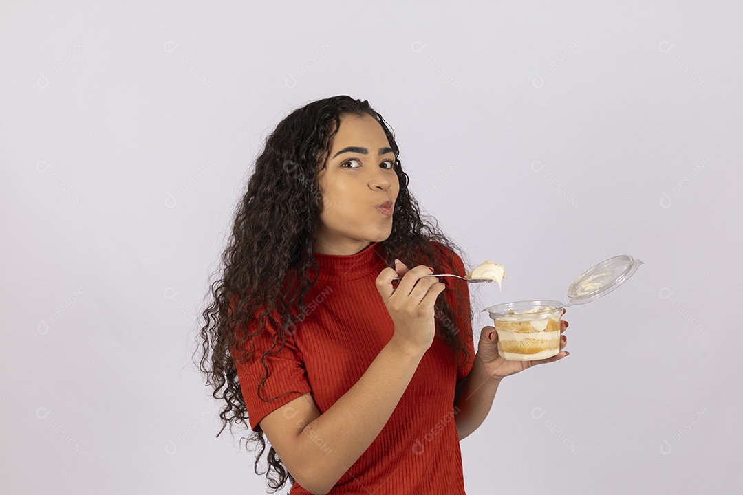 Jovem de boca cheia comendo um delicioso bolo de pote