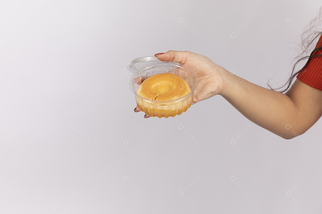 Pudim de leite condensado sobre a mão de uma mulher