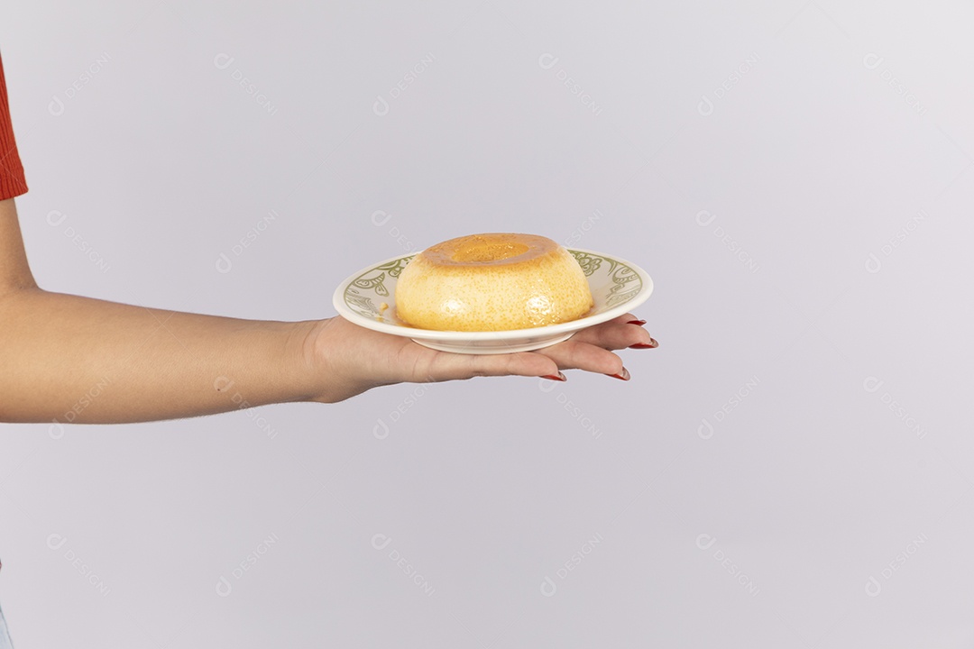 Mão de uma mulher com prato de pudim