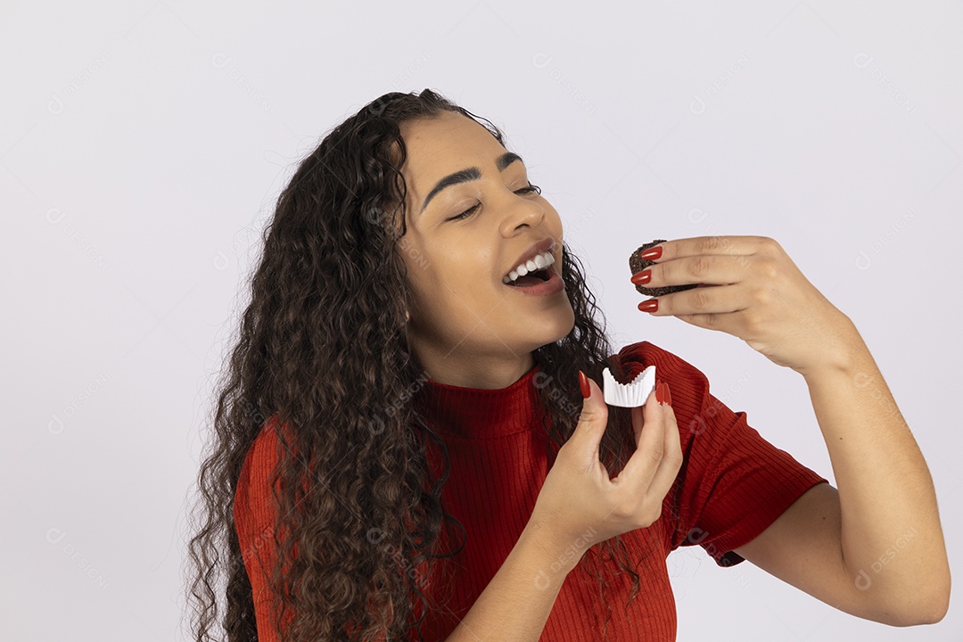Linda jovem comendo um brigadeiro