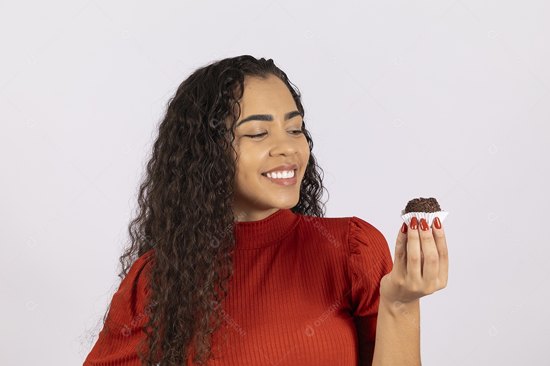 Uma linda mulher com brigadeiro na mão