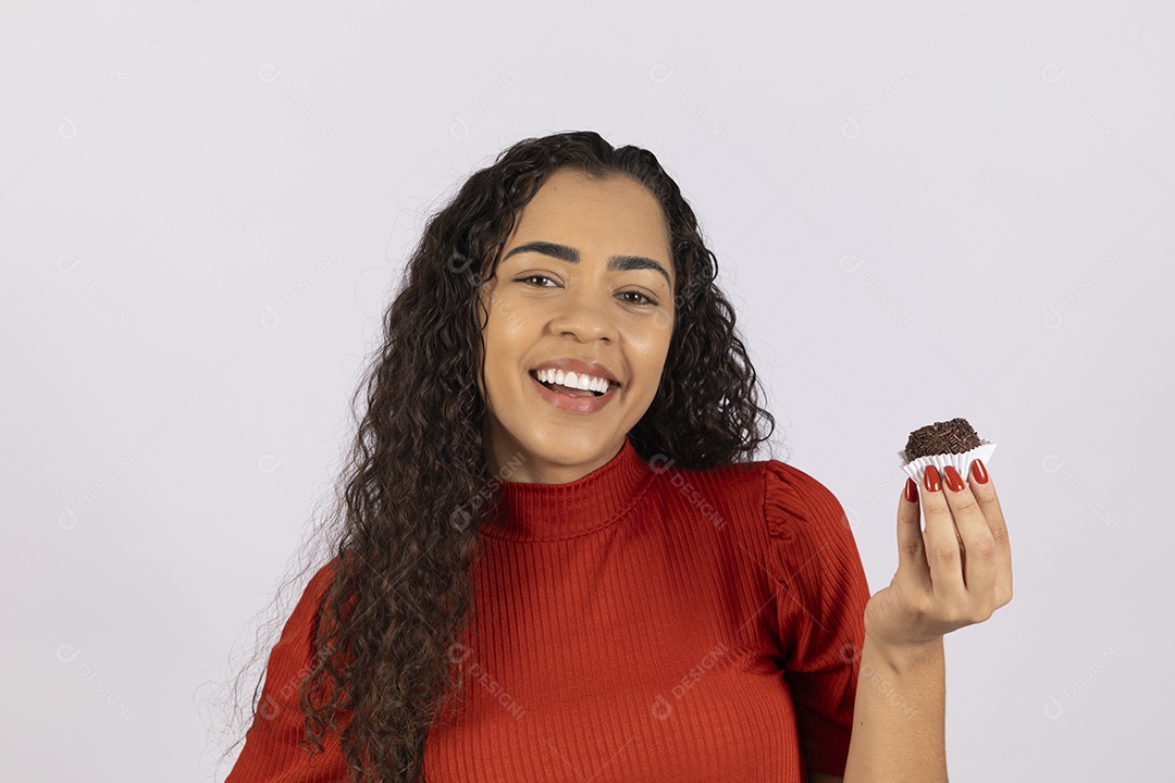 Linda jovem saboreando um delicioso brigadeiro gourmet