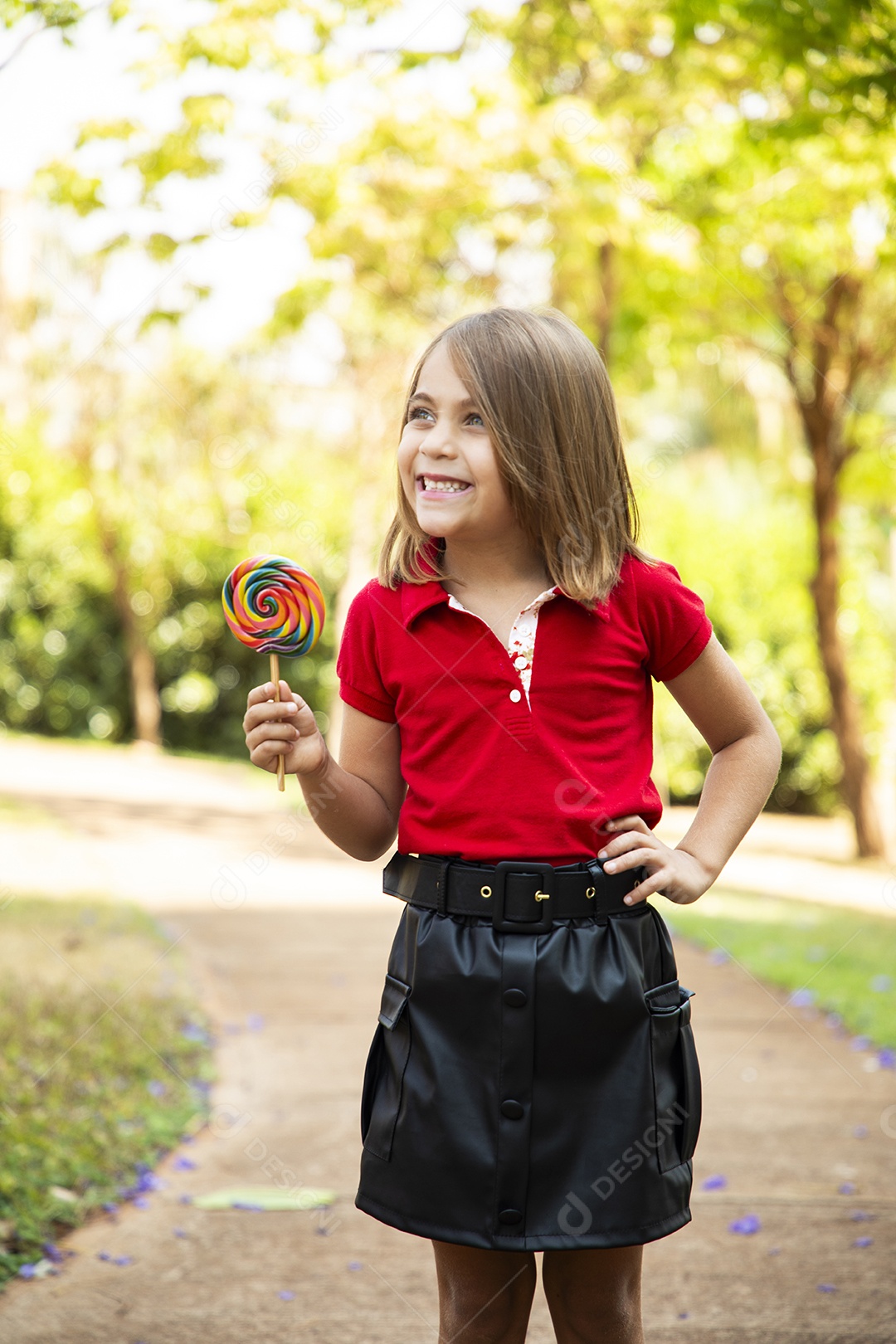 Uma garotinha linda contente com seu pirulitos nas mãos
