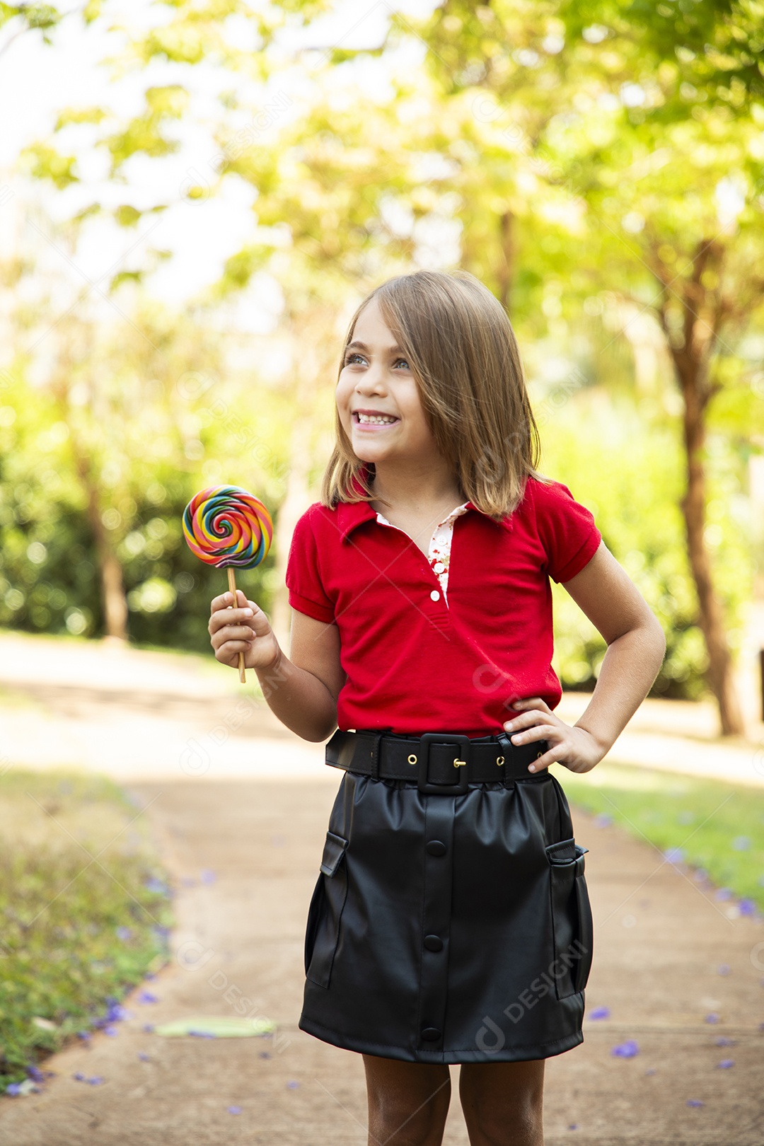 Uma linda menina de cabelos soltos com pirulito na mão