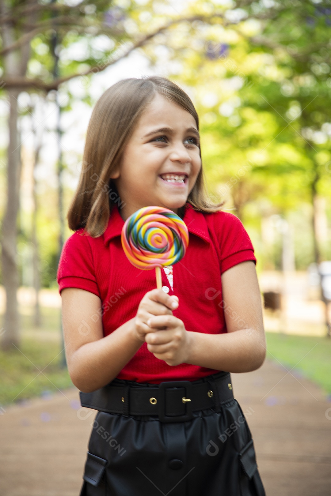 Uma adorável menina feliz com seu pirulito favorito