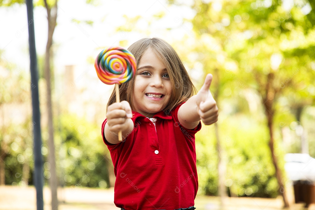Menina fofa feliz com seu pirulito favorito