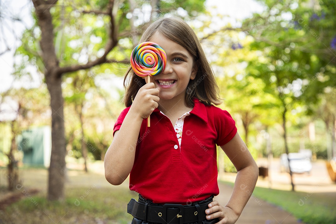 Uma menina fofa com pose de um pirulito no rosto