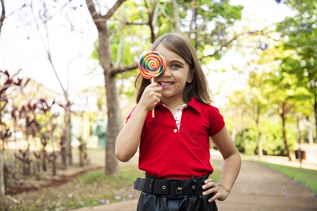 Uma menina fofa com pose de um pirulito no rosto