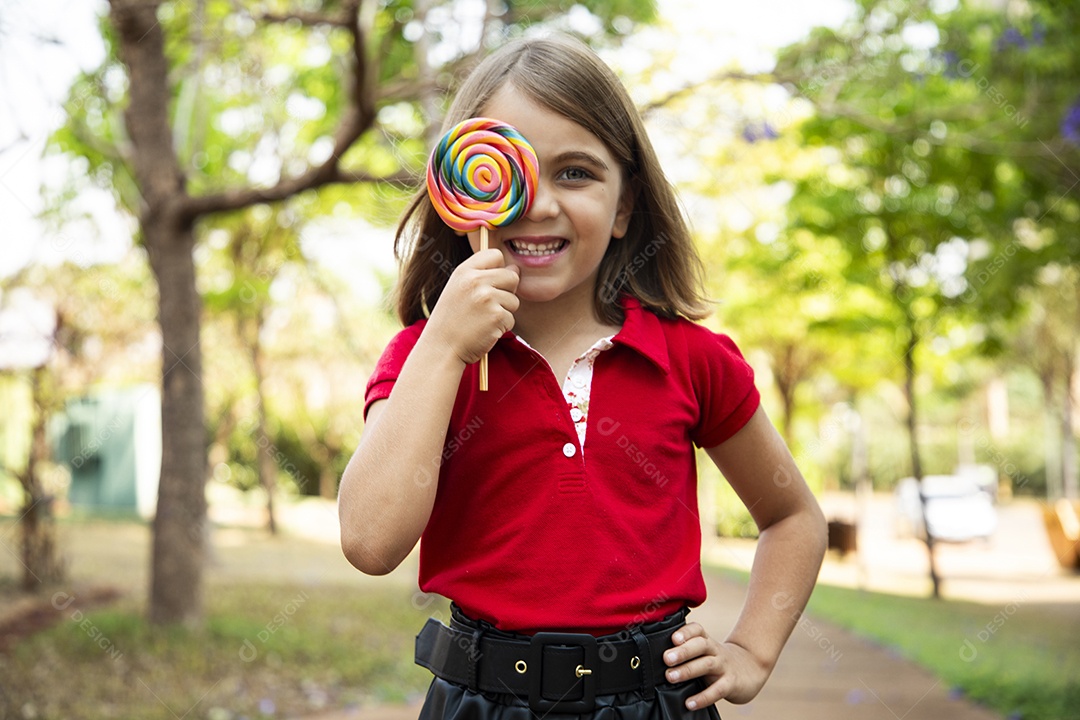 Uma fofa menina com pose de pirulito no olho
