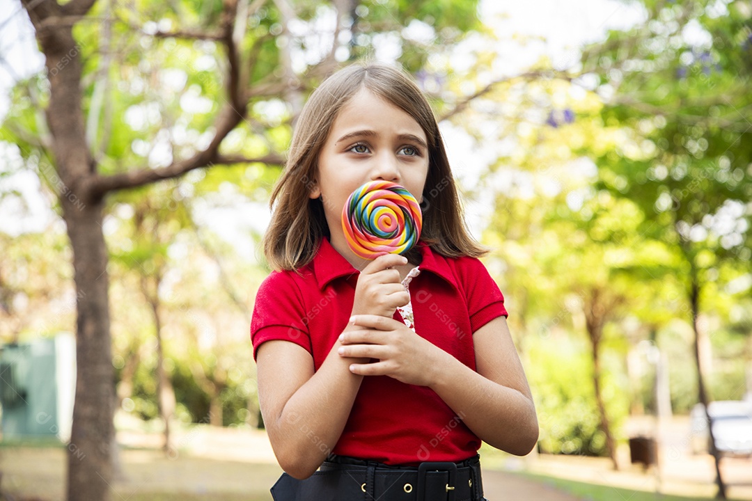 Uma linda menina estilosa com pirulito nas mãos