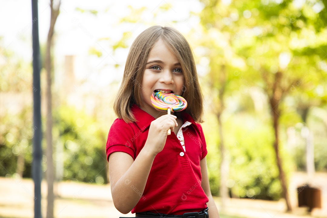Linda menina de cabelos curtos chupando um pirulito