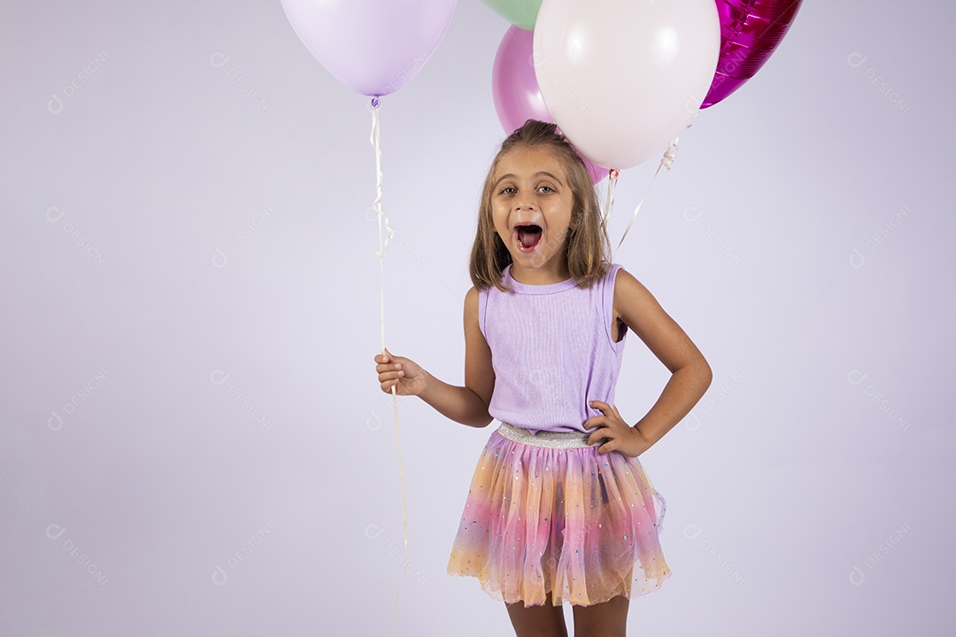 Menina fofa com mãos na cintura e segurando balões