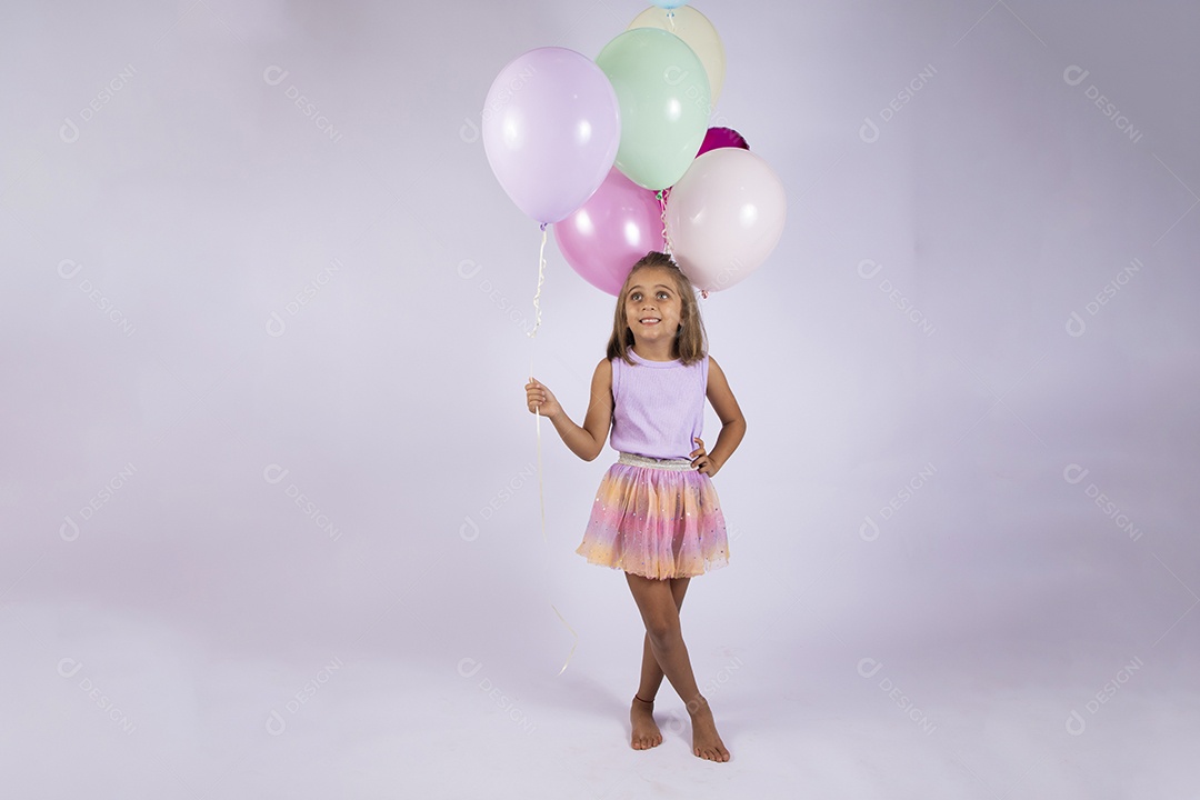 Menina com mão na cintura segurando balões