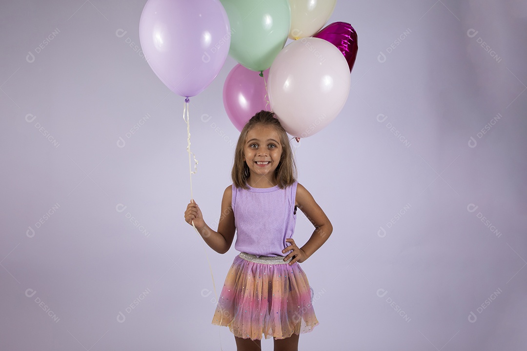 Menina segurando balões  com mãos na cintura