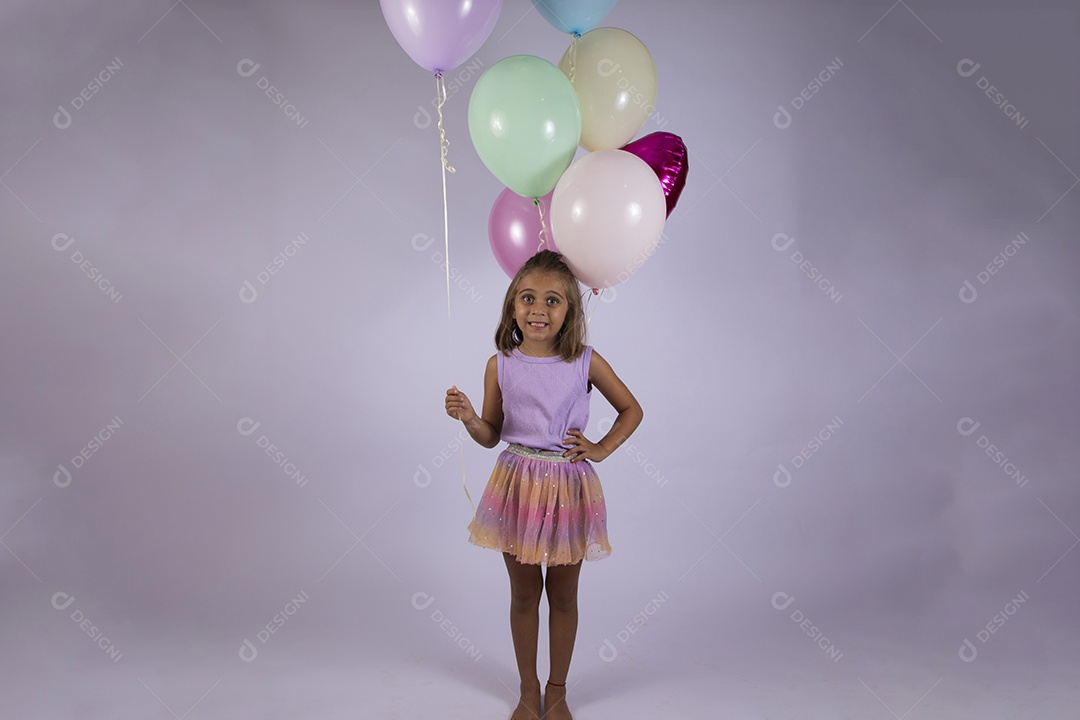 Menina linda com mão na cintura com balões na mãos