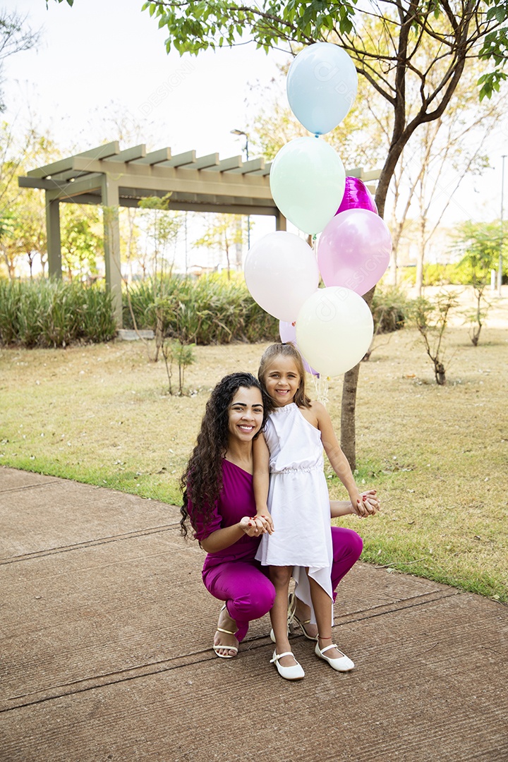 Menina fofa e sua mãe tirando fotos para aniversário