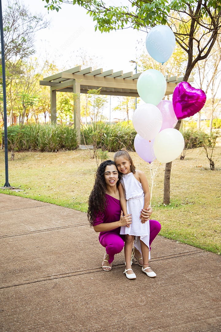 Mulher e sua filha no parque tirando foto para aniversário
