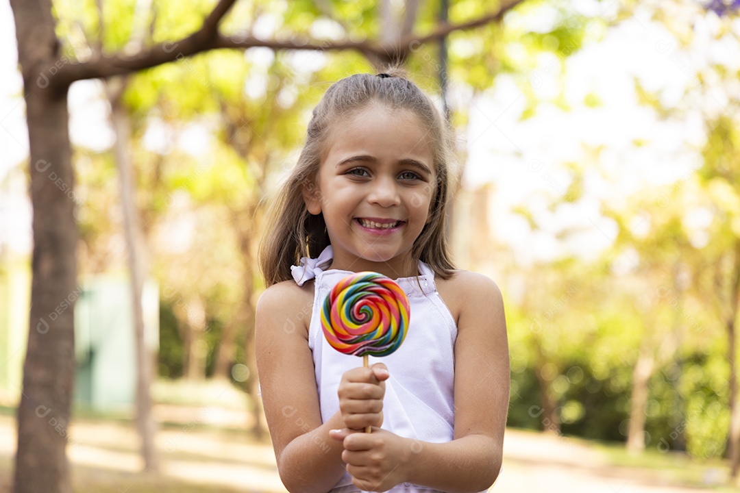 Garotinha linda segurando pirulito nas mãos