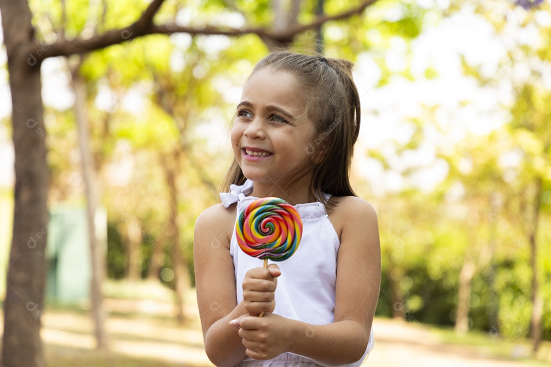 Menina feliz chupando seu pirulito