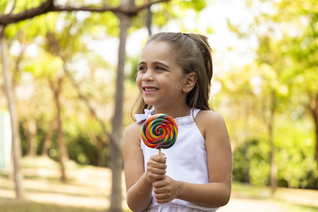 Menina com seu pirulito colorido nas mãos