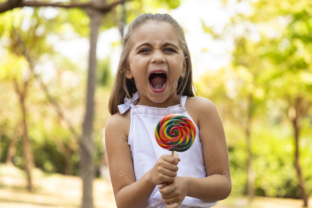 Menina feliz chupando seu pirulito