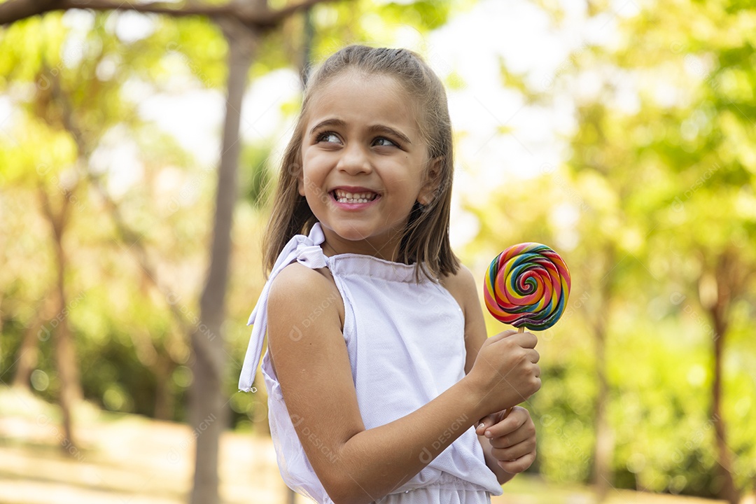 Menina feliz segurando pirulito