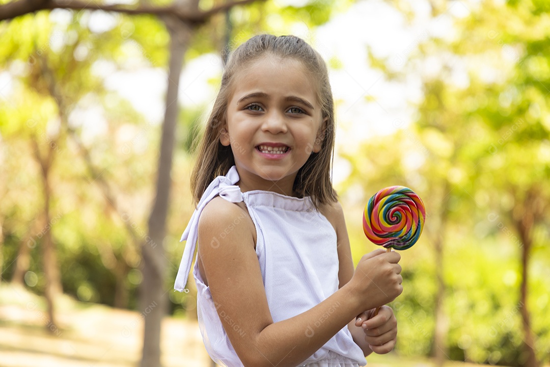 Menina linda feliz segurando pirulito