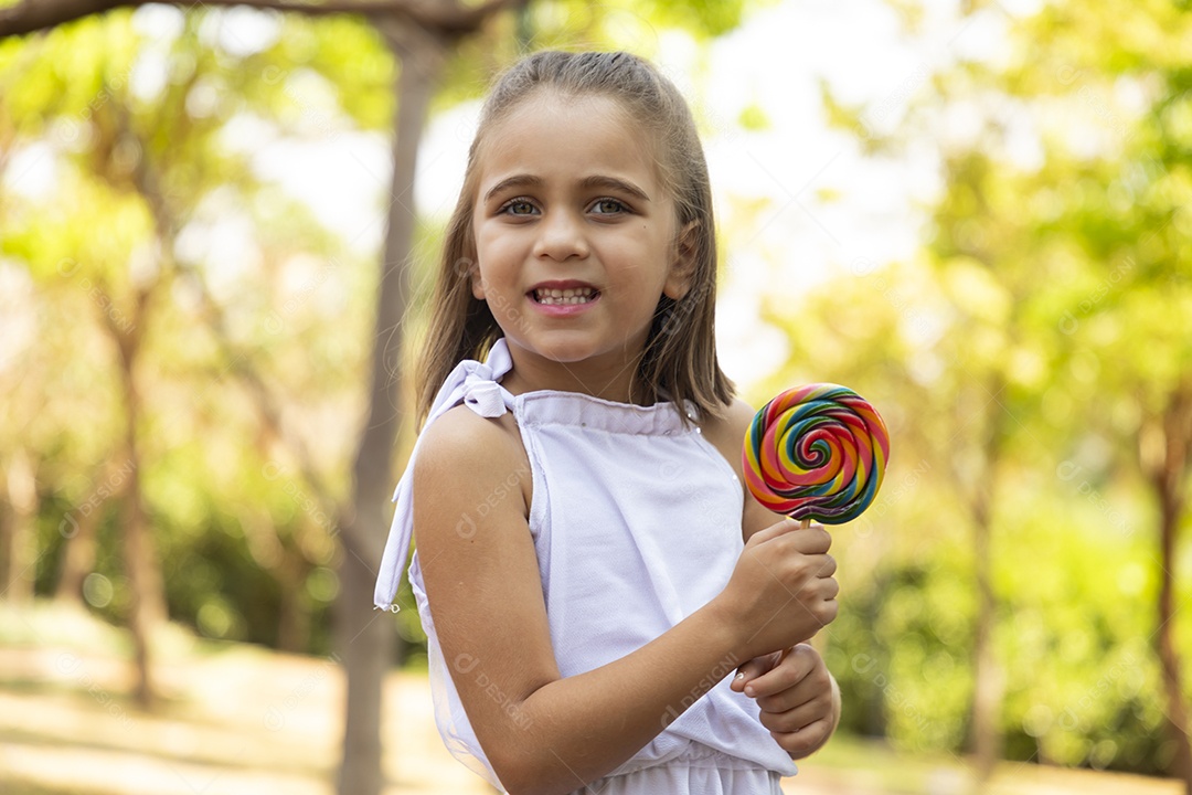 Menina fofa segurando seu pirulito na mãos
