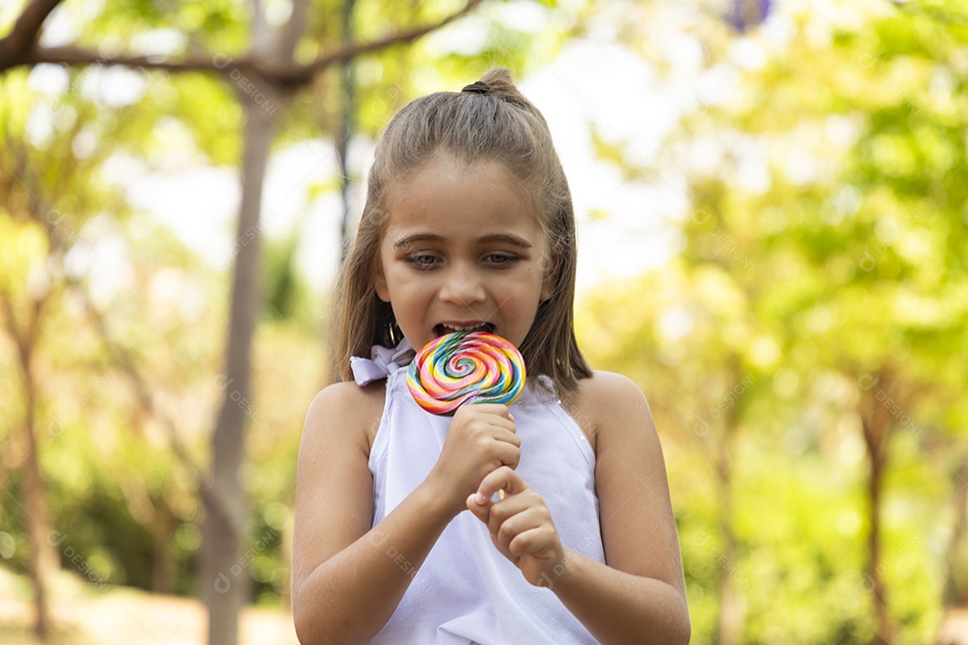 Menina linda chupando seu pirulito favorito