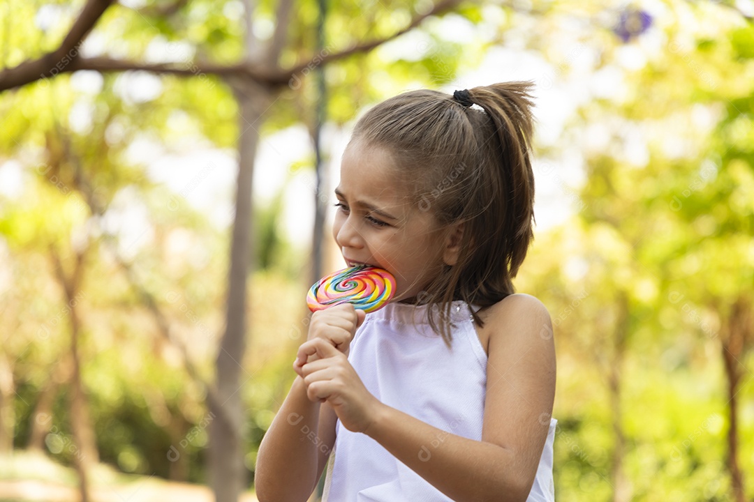 Menina feliz chupando seu pirulito