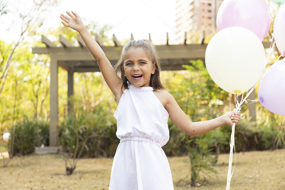 Linda garotinha com muitos balões na mão
