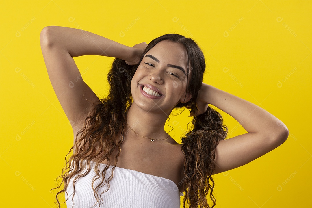 Jovem sorridente com mãos no cabelo