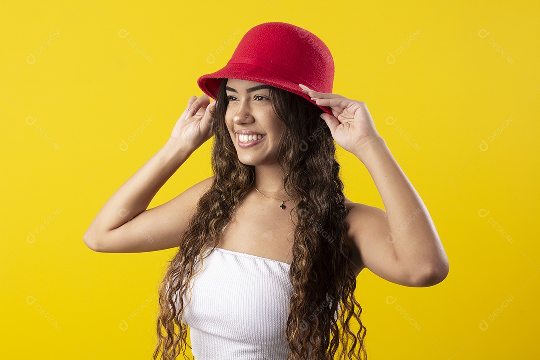 Jovem bonita com mãos no chapéu