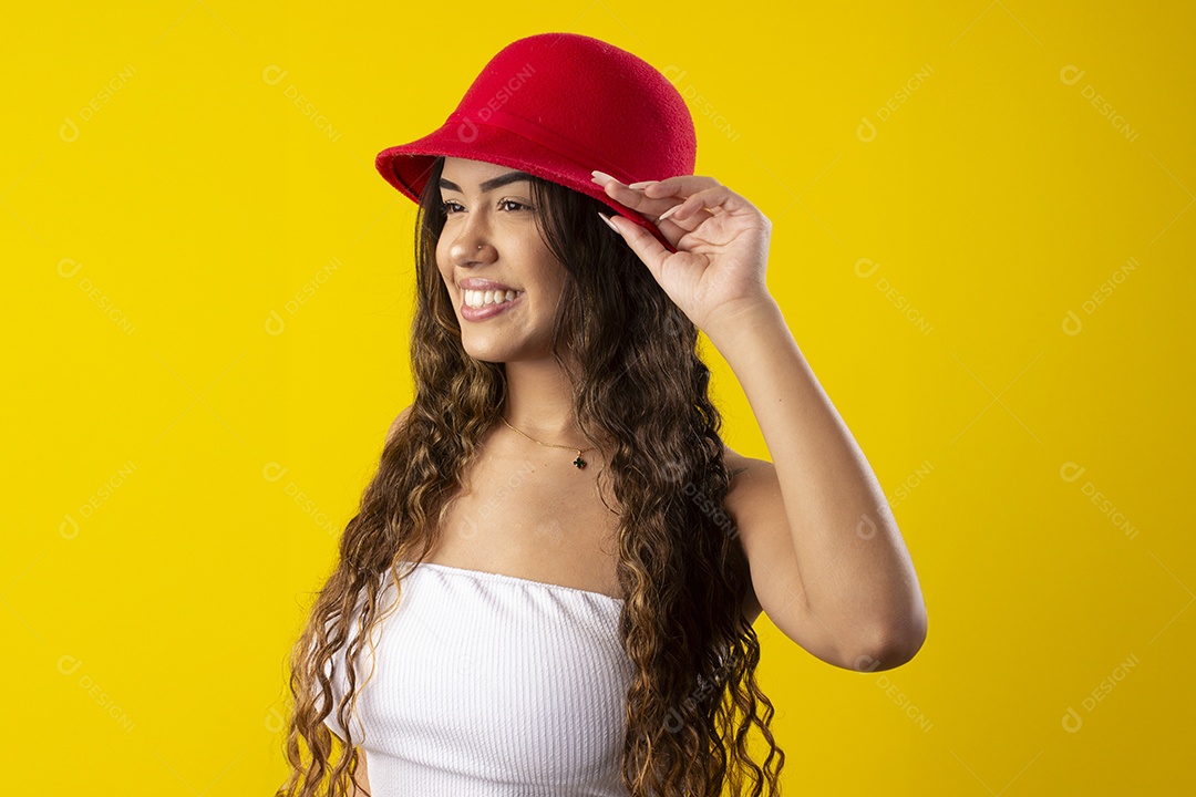 Jovem linda com mãos no chapéu