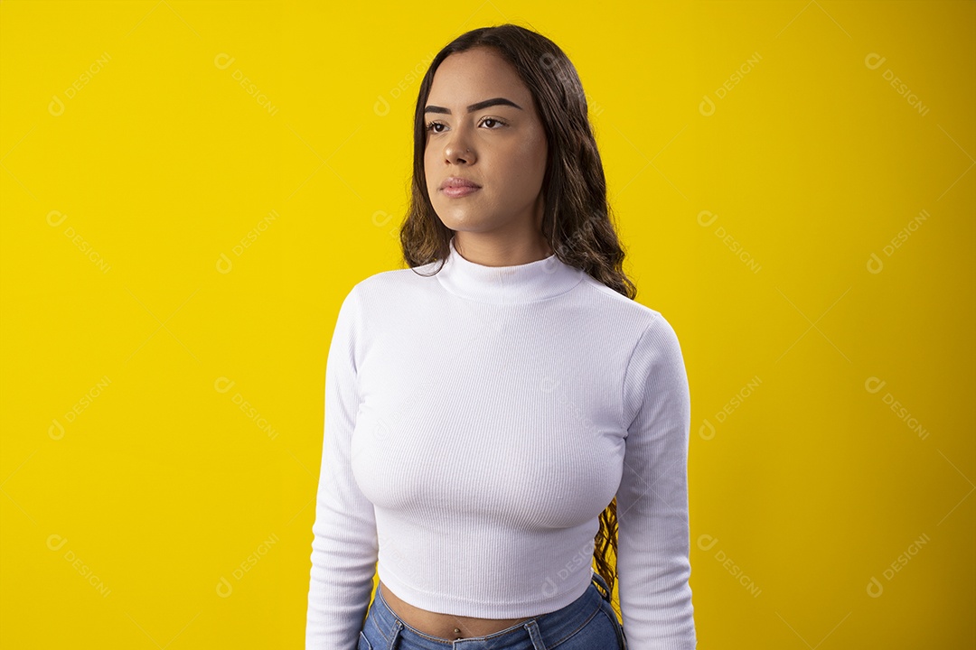 Jovem seria e linda sobre fundo amarelo