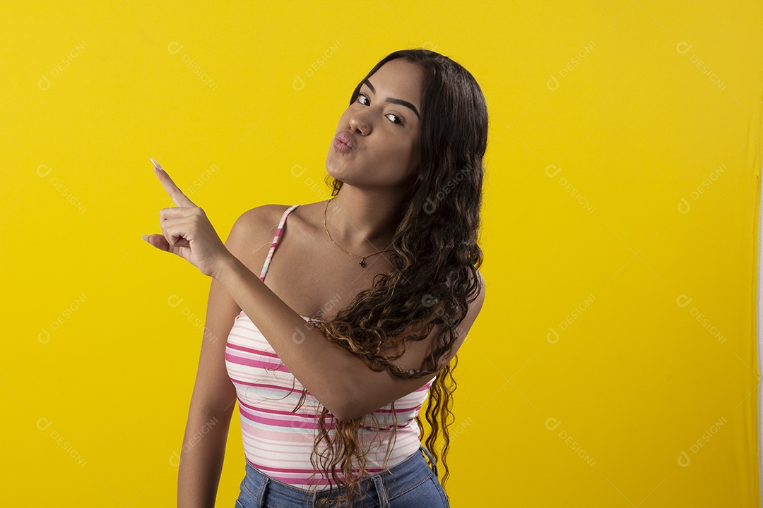 Linda garota apontando para o lado fazendo bico
