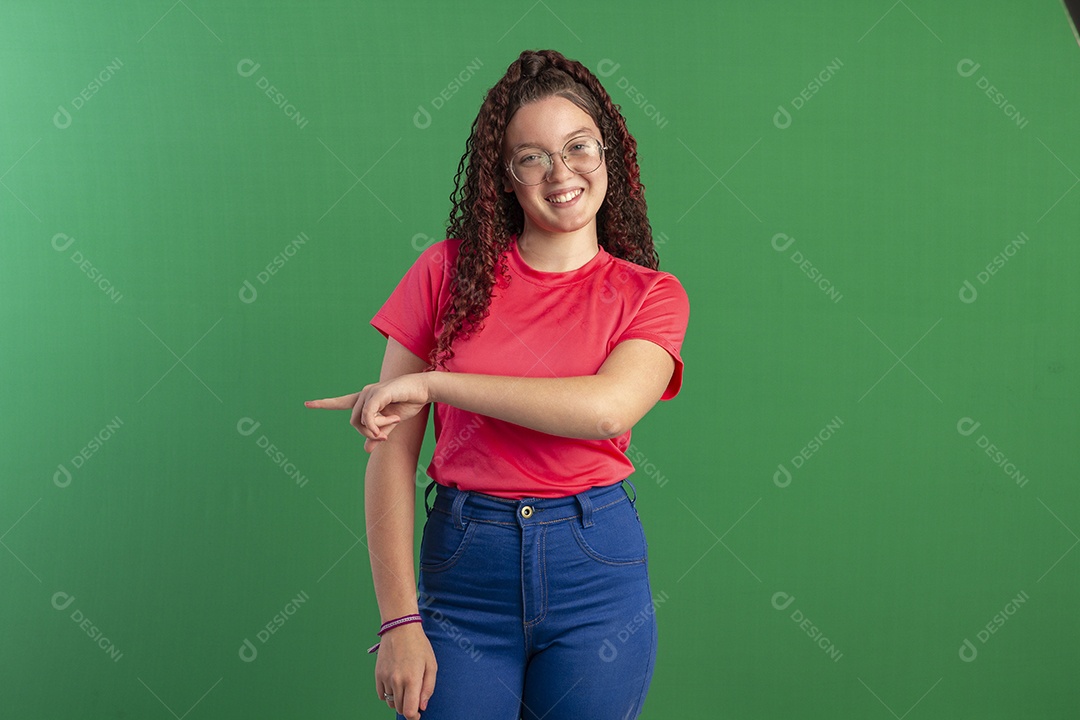 Menina cacheada bonita apontando para o lado