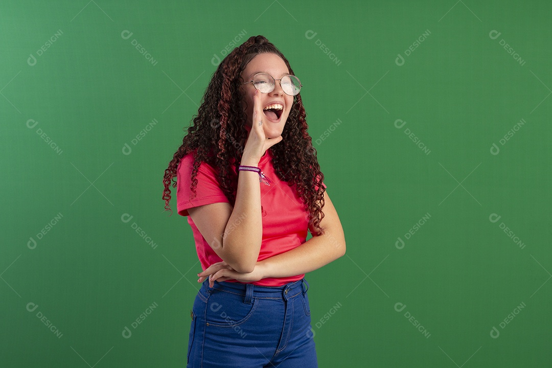 Menina cacheada com mão na boca gesto de grito