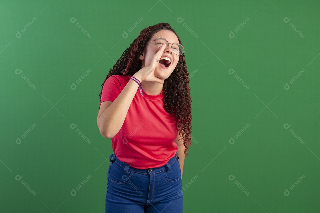 Menina cacheada com mão na boca gesto de grito