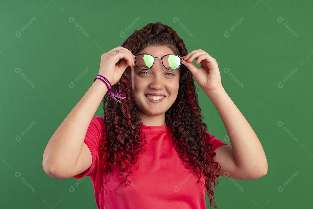 Linda menina com mãos nos óculos e sorrindo