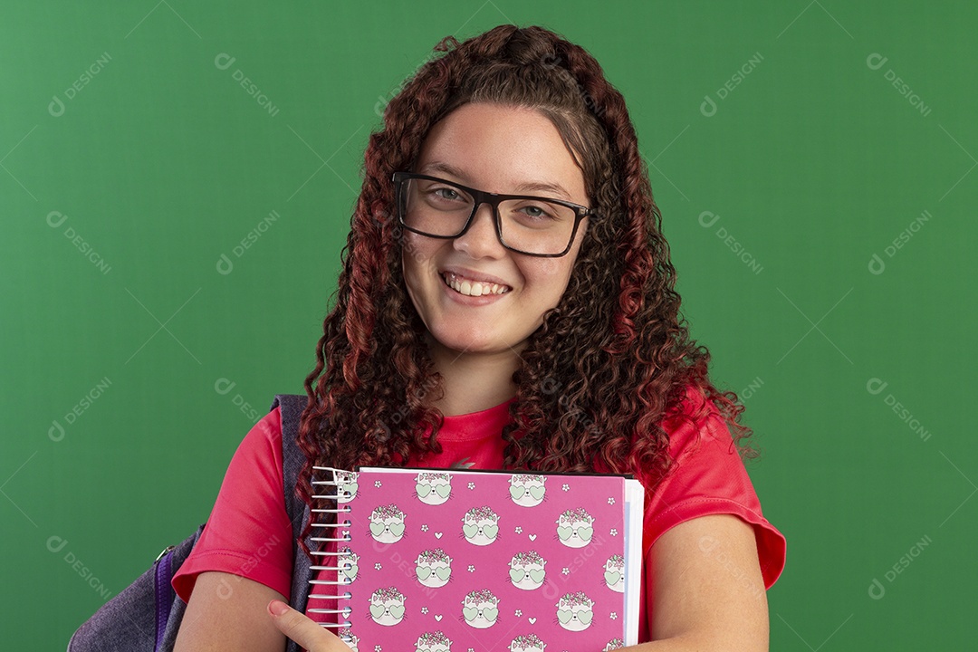 Jovem feliz com cadernos nas mãos e bolsa nas costas