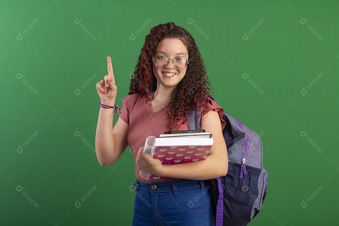 Menina segurando caderno e apontando para cima