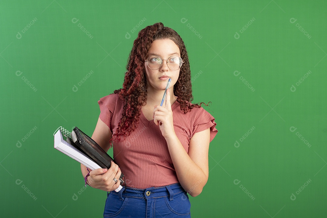 Garota com cadernos nas mãos para estudo pensativa