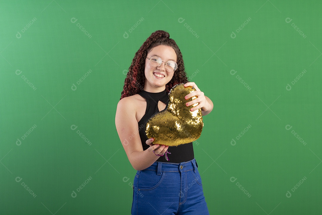 Menina sorrindo segurando coração de pelúcia