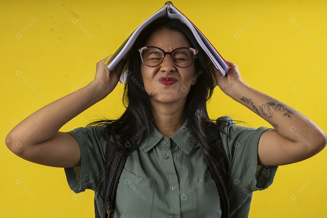 Jovem com livro na cabeça e fazendo careta