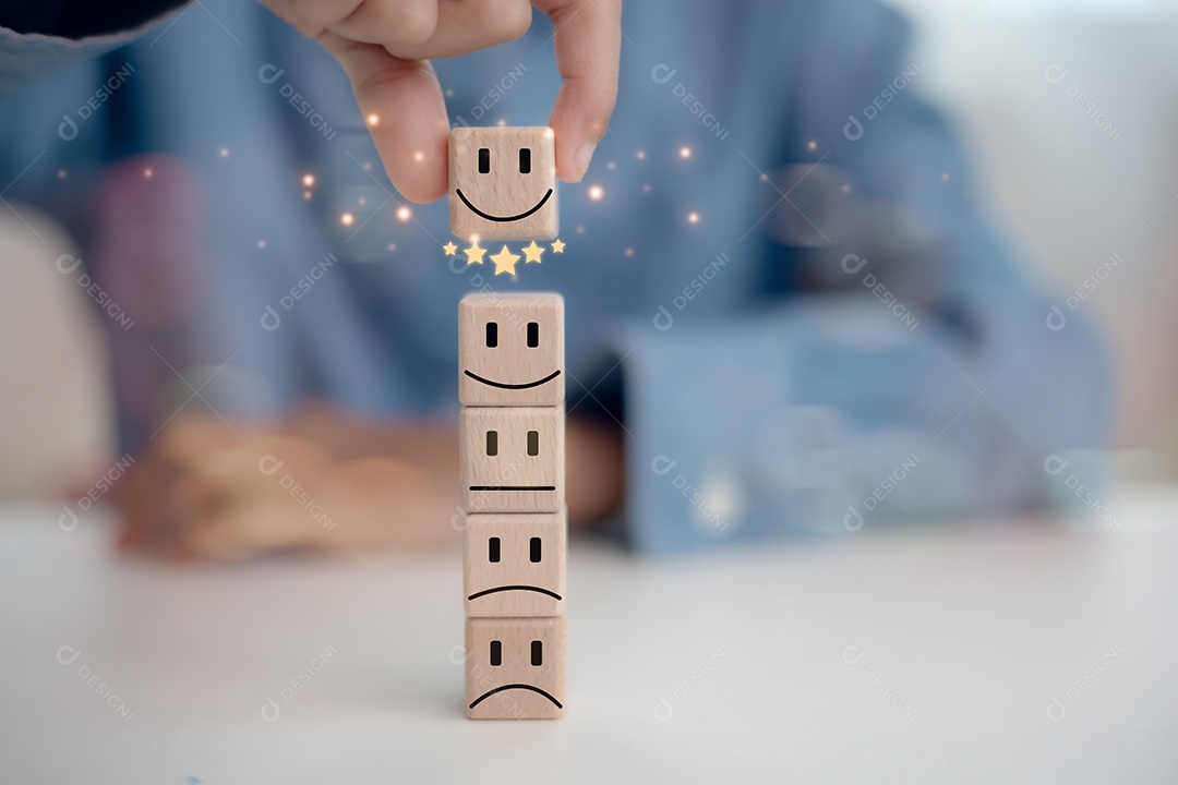 A businessmans hand chooses a smiling face in a circle of wooden blocks