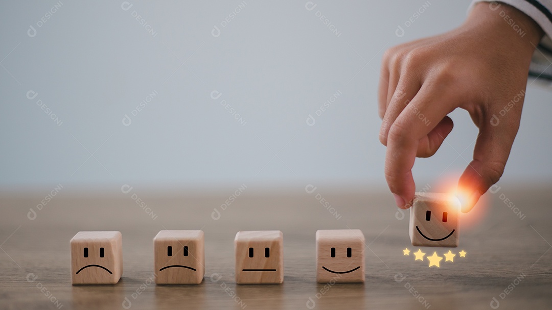 A mão de um empresário escolhe um rosto sorridente no cubo de bloco de madeira