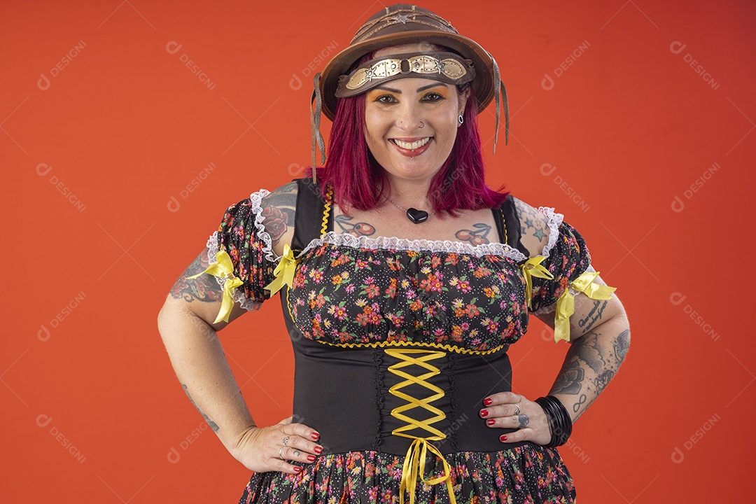 Jovem com trajes juninos e mão na cintura