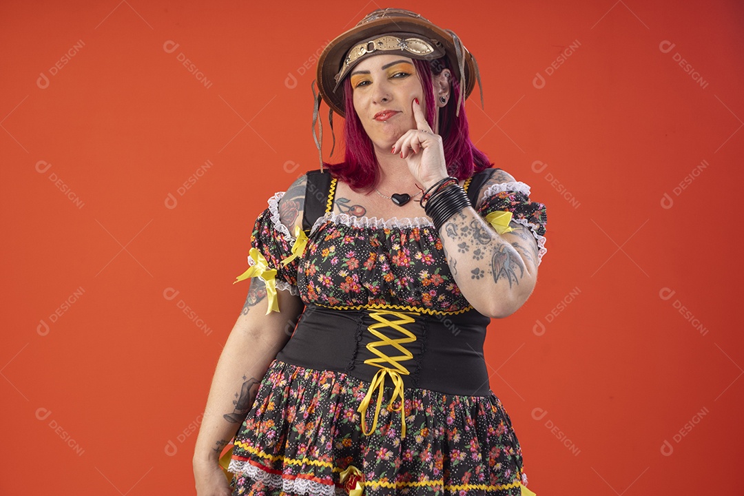 Jovem bonita com trajes juninos com mão no rosto pensativa